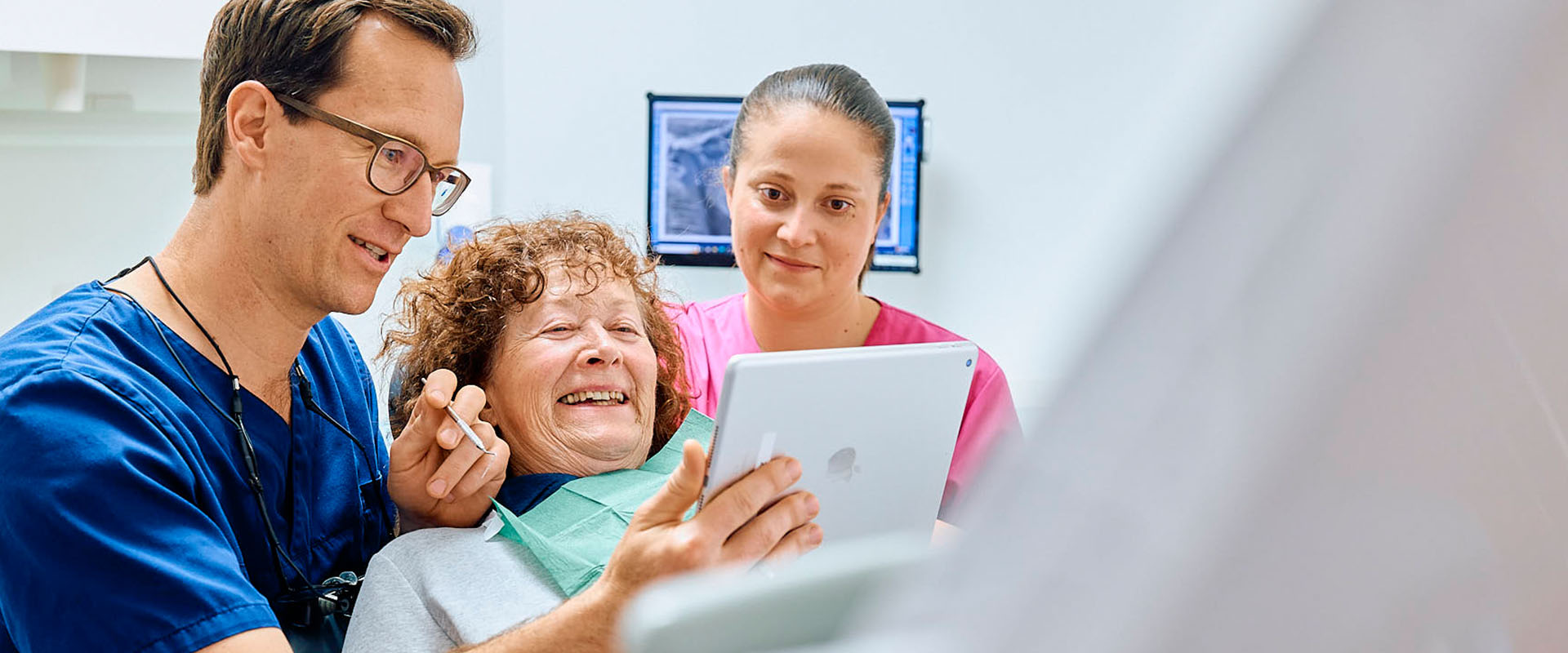 Zahnarzt Dr. Pfau zeigt Patientin das 3d-Röntgen Bild auf einem Tablet in der Zahnarztpraxis Pfau in Rottweil
