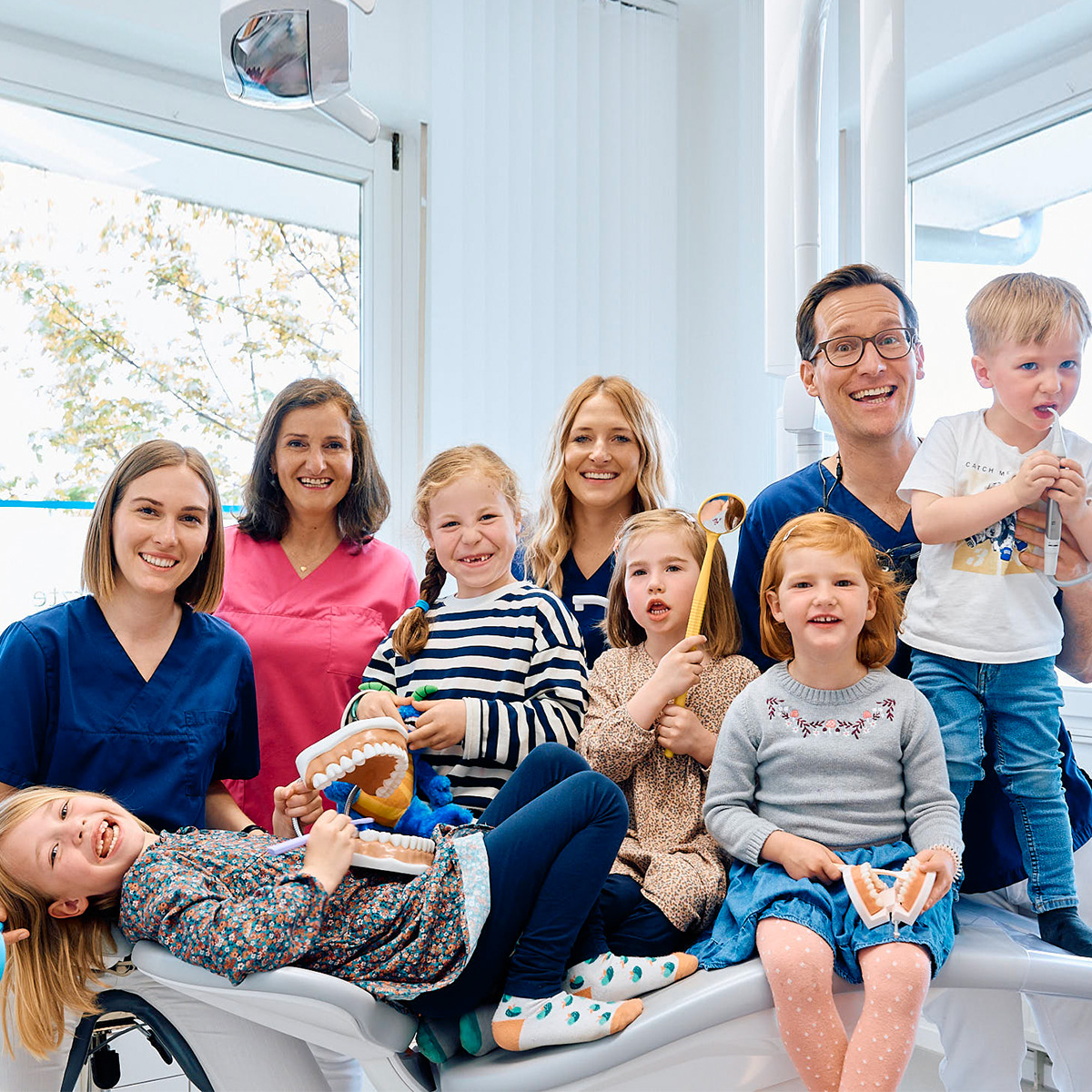 Gruppenbild mit Zahnärzten und Kindern in der Zahnarztpraxis Pfau in Rottweil