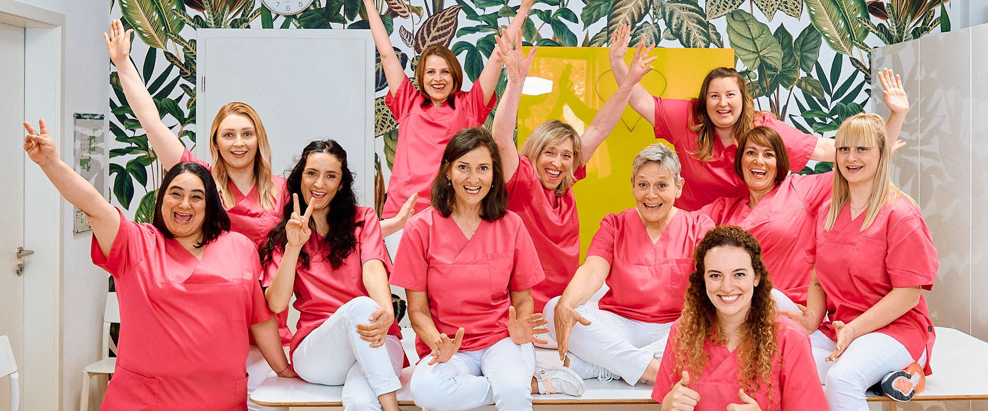 Gruppenbild der Prophylaxe-ZFA zeigt elf jubelnde und lachende Frauen in rosa Shirts in der Zahnarztpraxis Pfau in Rottweil