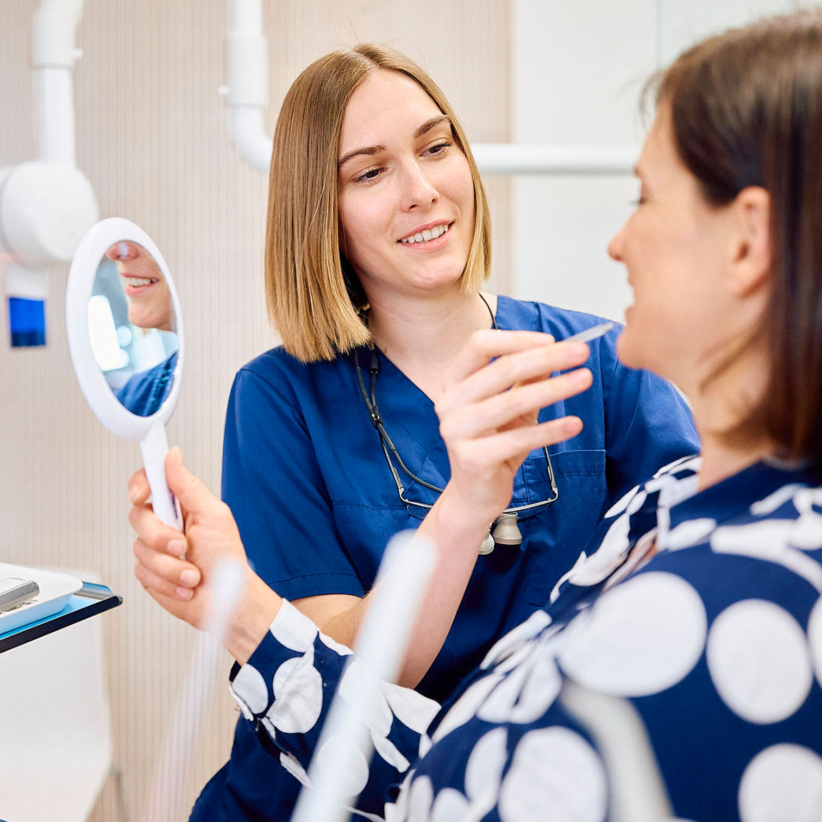 Zahnärztin erklärte Patientin die Funktion des Gebisses, Patietin sieht ihr im Spiegel in Rottweil zu.