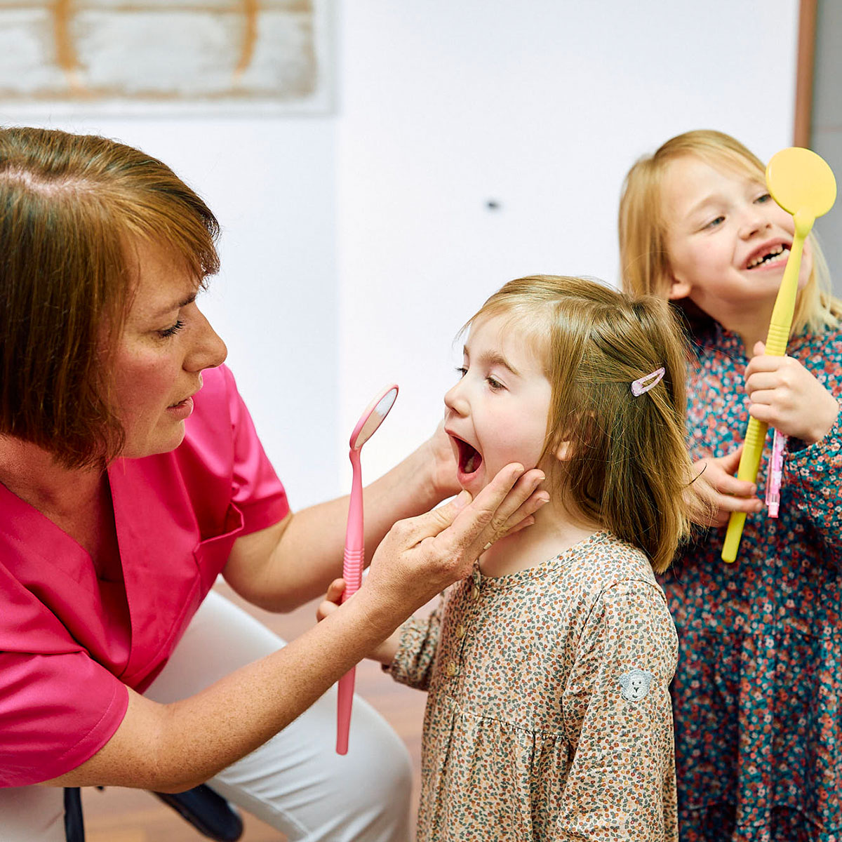 ZFA sieht kleinem Mädchen in den Mund bei der Zahnarztpraxis Pfau in Rottweil